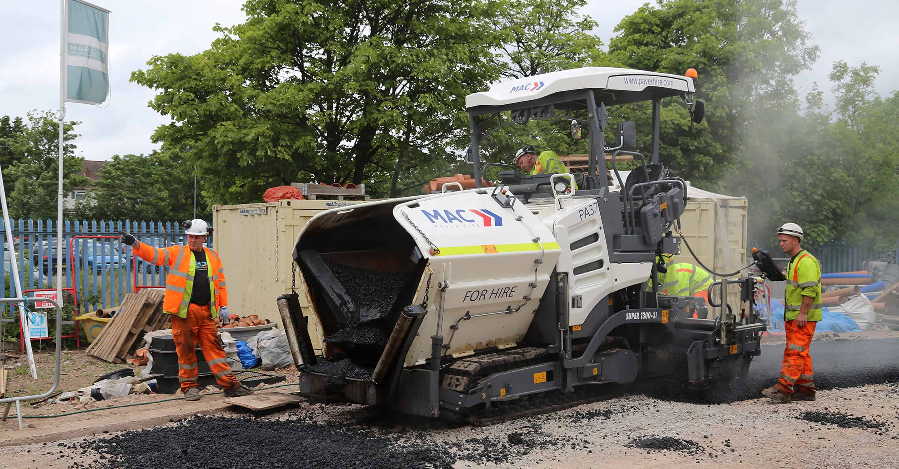MAC Surfacing gang laying asphalt with an operated paver